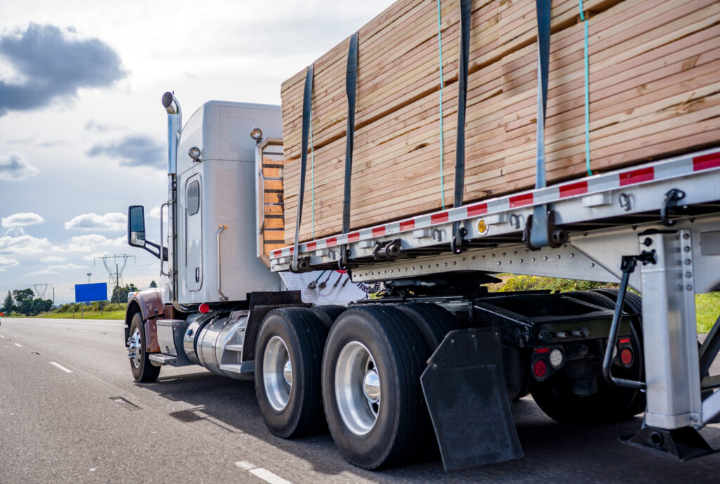 Semi truck hauling a load of lumber on the highway